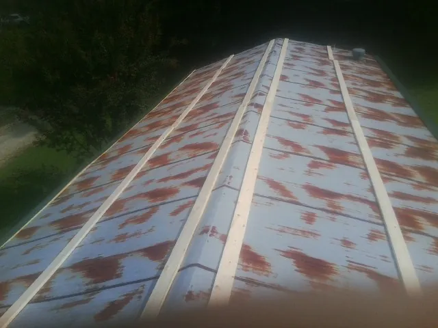 Rusted metal roof panels with new wood purlins before replacement — Storm Damage Roof Repair in Hooker by Roofing Brothers
