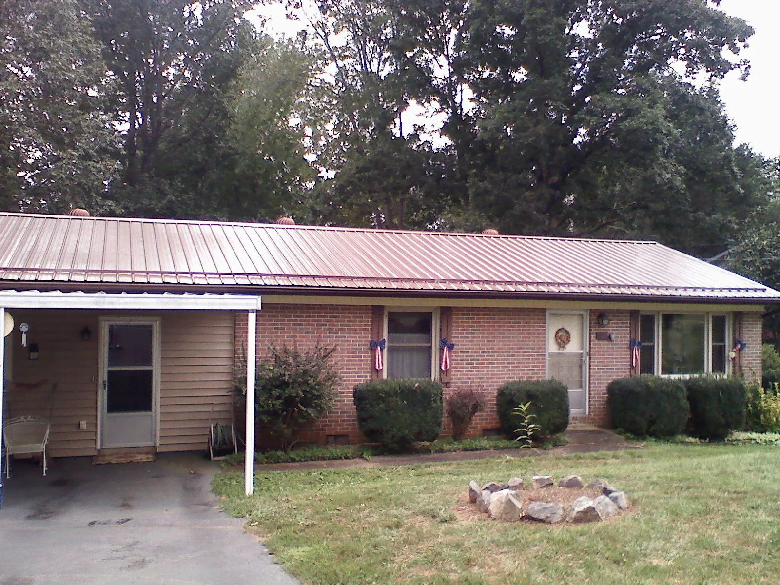 Bronze metal roof and carport on a brick ranch home — Roof Repair work by our crew in Hooker